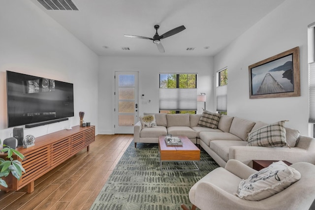 living room featuring wood-type flooring and ceiling fan