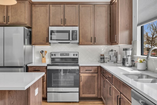 kitchen with appliances with stainless steel finishes, decorative backsplash, and sink