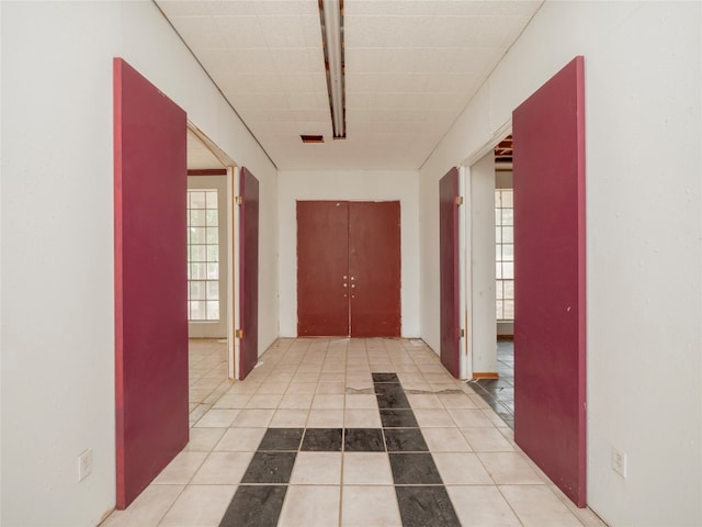 corridor featuring plenty of natural light and light tile patterned floors