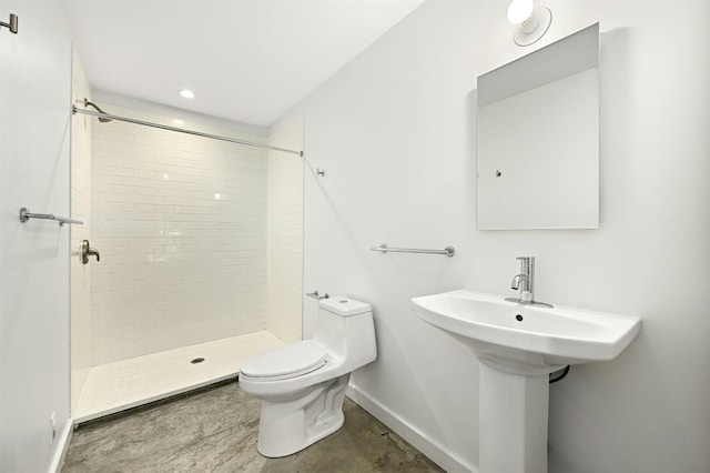 bathroom with a tile shower and toilet