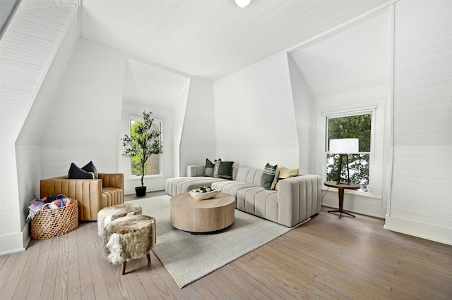 living room featuring wood-type flooring and vaulted ceiling