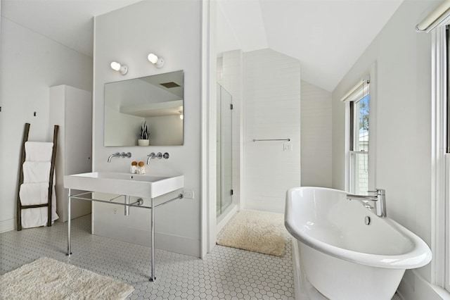 bathroom featuring shower with separate bathtub, lofted ceiling, and tile patterned floors