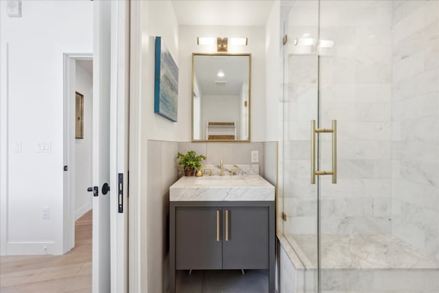 bathroom featuring vanity, wood-type flooring, and a shower with door