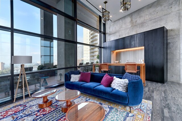 living room featuring a high ceiling, expansive windows, a chandelier, and wood-type flooring