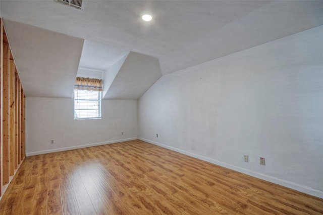 additional living space featuring wood-type flooring and vaulted ceiling