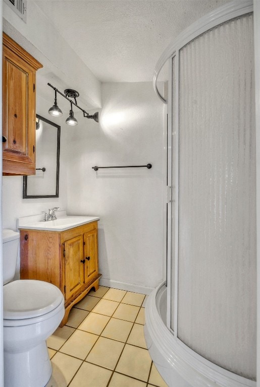 bathroom with a textured ceiling, vanity, a shower with shower door, tile patterned flooring, and toilet