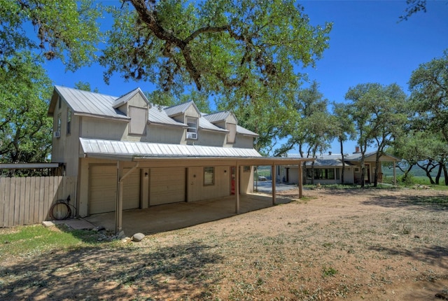 rear view of house featuring a garage and a carport