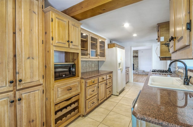 kitchen with white refrigerator with ice dispenser, sink, light tile patterned floors, and beam ceiling