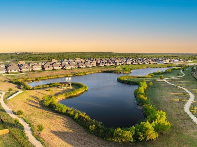 aerial view at dusk featuring a water view