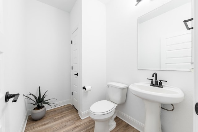 bathroom with hardwood / wood-style flooring and toilet