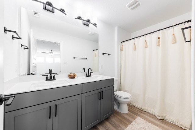 bathroom featuring ceiling fan, toilet, wood-type flooring, and vanity