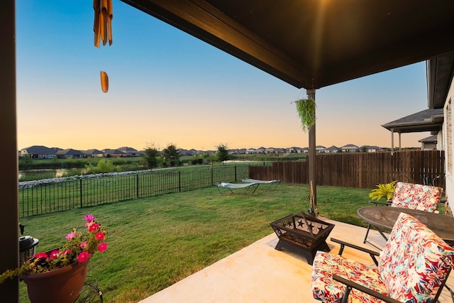 yard at dusk featuring a fire pit and a patio area