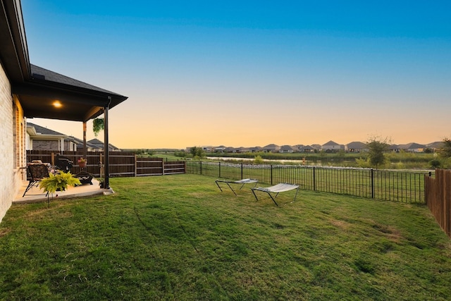 yard at dusk featuring a patio area