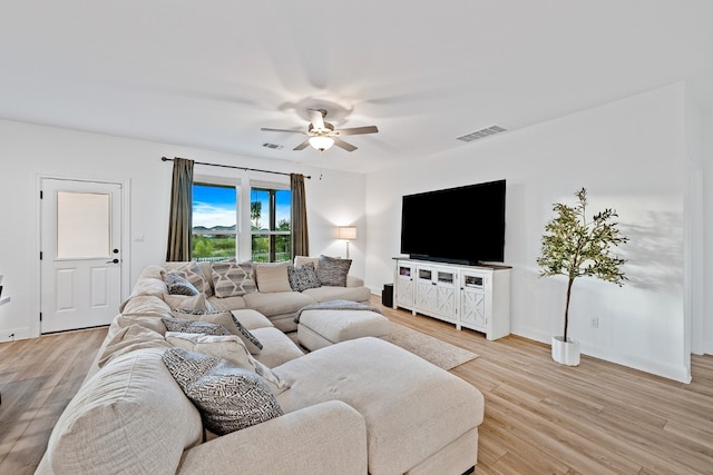 living room with light hardwood / wood-style flooring and ceiling fan