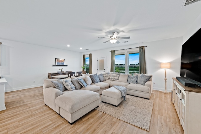 living room featuring ceiling fan and light hardwood / wood-style flooring