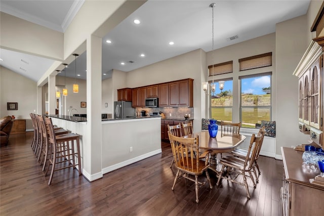 dining room featuring an inviting chandelier, crown molding, and dark hardwood / wood-style flooring