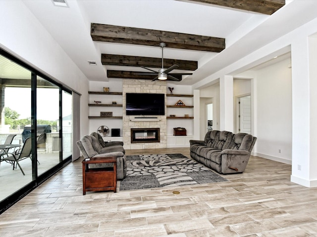 living room featuring beamed ceiling, ceiling fan, and a fireplace