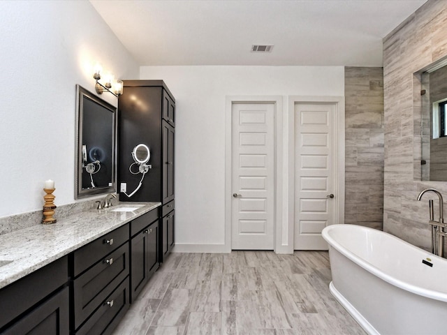 bathroom with vanity and a tub