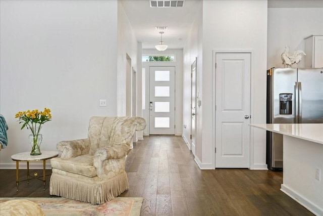 foyer featuring dark wood finished floors, visible vents, and baseboards