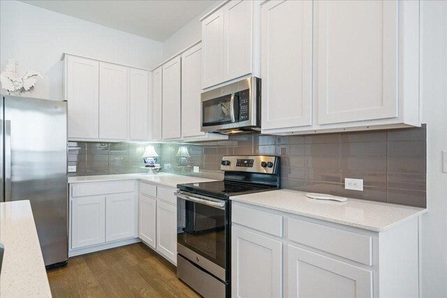 kitchen featuring dark hardwood / wood-style floors, appliances with stainless steel finishes, and white cabinetry