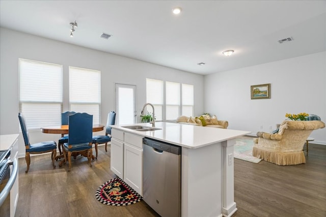 kitchen with dark hardwood / wood-style floors, a center island with sink, stainless steel dishwasher, sink, and white cabinetry