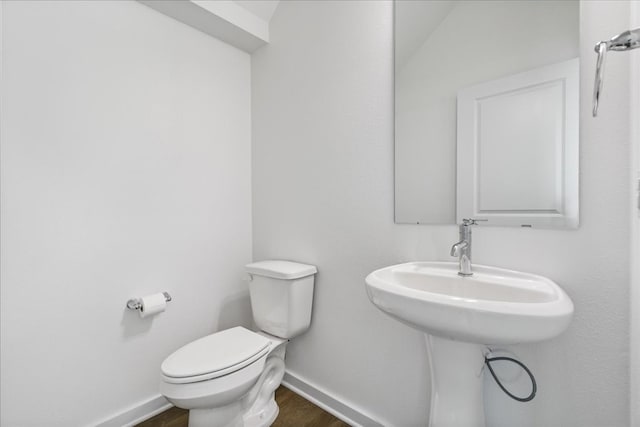 bathroom with lofted ceiling, wood-type flooring, and toilet