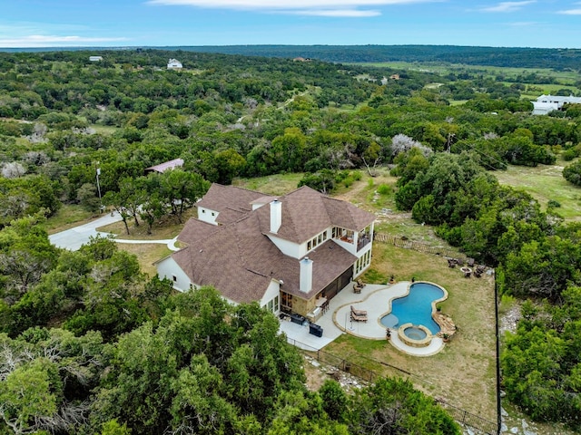 drone / aerial view with a wooded view