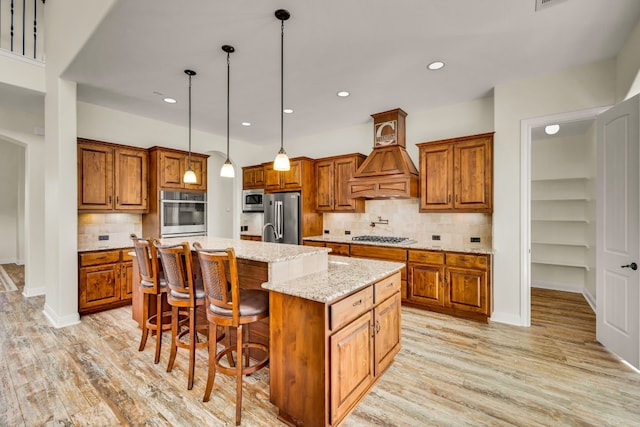 238 Landons Way, Georgetown, TX 78633 - kitchen featuring appliances with stainless steel finishes, brown cabinetry, a kitchen island with sink, decorative backsplash, and recessed lighting