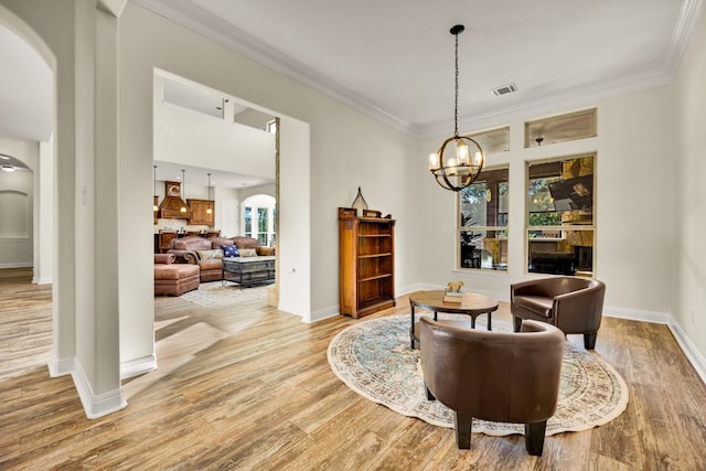 dining space with wood-type flooring, a fireplace, crown molding, and a chandelier