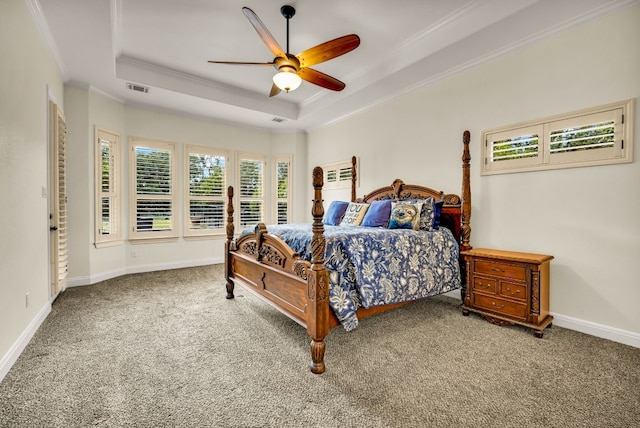 carpeted bedroom with ornamental molding, ceiling fan, and a raised ceiling