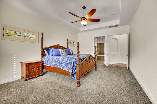 carpeted bedroom with a raised ceiling, connected bathroom, crown molding, and ceiling fan