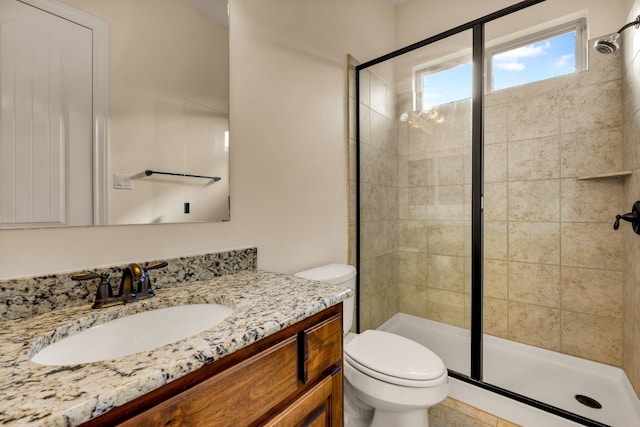 bathroom with vanity, a shower with shower door, and toilet