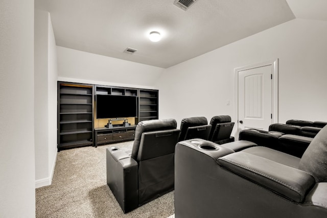 carpeted cinema room featuring lofted ceiling