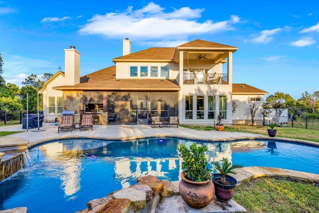 rear view of house featuring a balcony, a fenced in pool, a patio area, stucco siding, and fence