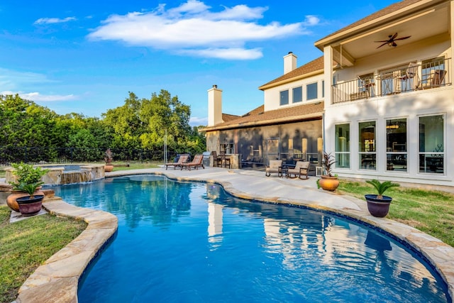 view of pool featuring fence, ceiling fan, a pool with connected hot tub, and a patio area