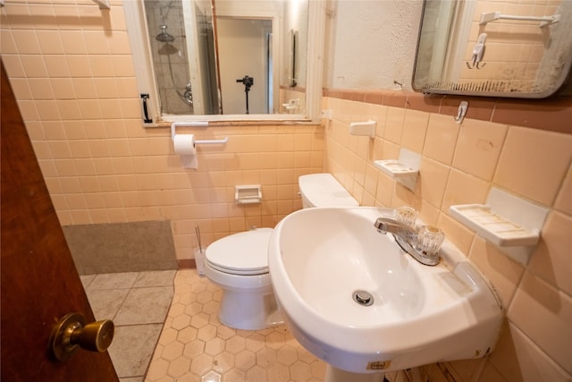 bathroom with tile walls, toilet, sink, tile patterned floors, and decorative backsplash