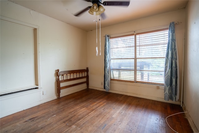 empty room with dark wood-type flooring and ceiling fan