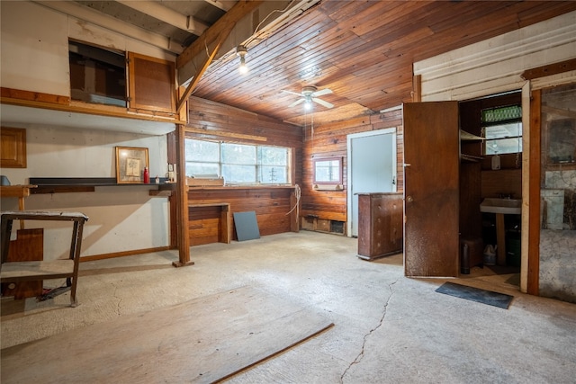 interior space with vaulted ceiling, wood ceiling, ceiling fan, and wooden walls