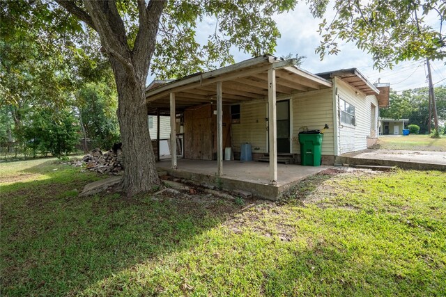 rear view of house with a yard and a patio