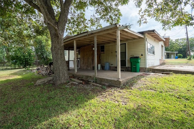1816 Davis St, Taylor, TX 76574 - rear view of house featuring a lawn and a patio area
