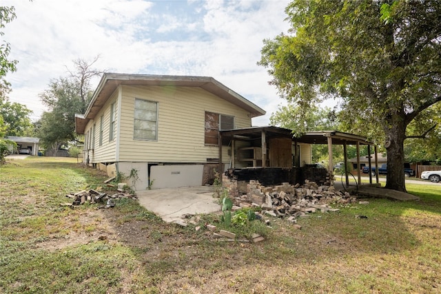 rear view of property featuring a garage and a lawn