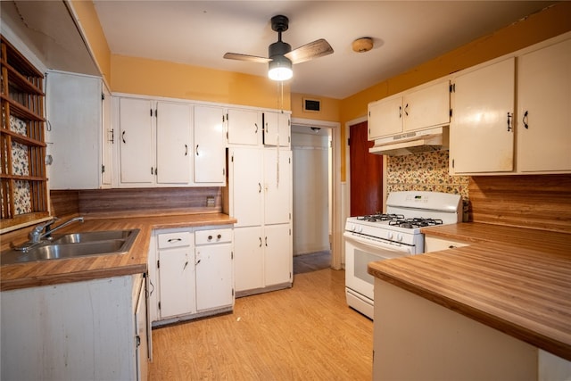 kitchen featuring tasteful backsplash, sink, ceiling fan, white gas stove, and light hardwood / wood-style floors