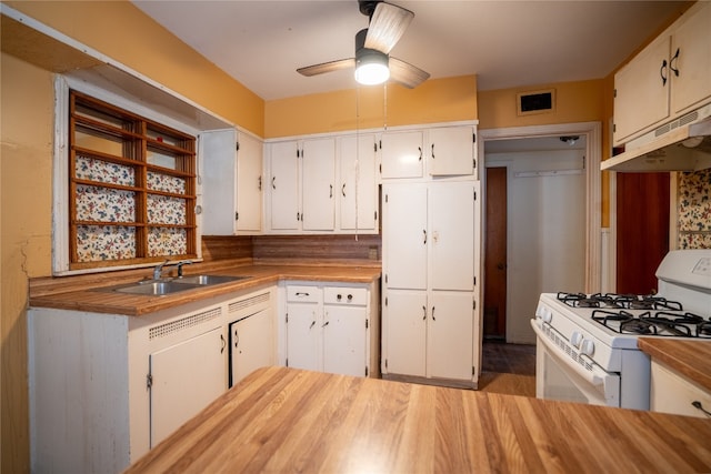 kitchen with white cabinetry, sink, ceiling fan, and white gas range