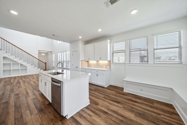 kitchen with dark hardwood / wood-style flooring, white cabinets, sink, a center island with sink, and dishwasher