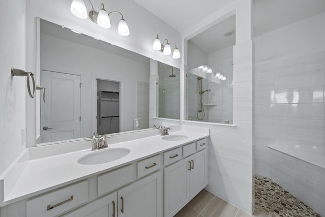 bathroom with a tile shower, tile patterned floors, and vanity