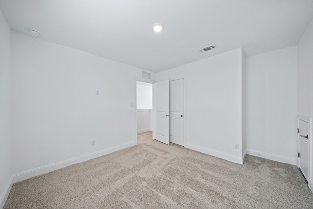 unfurnished room featuring light carpet