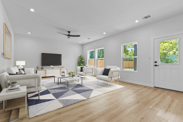 living room featuring ceiling fan and light hardwood / wood-style flooring