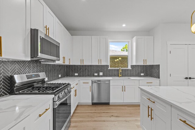 kitchen with white cabinets, stainless steel appliances, and sink