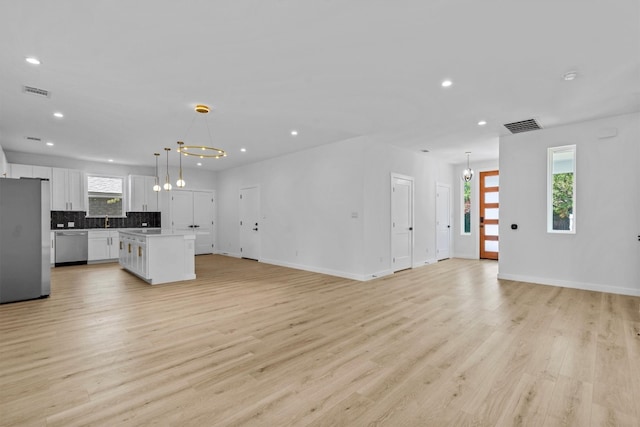 unfurnished living room featuring sink and light wood-type flooring