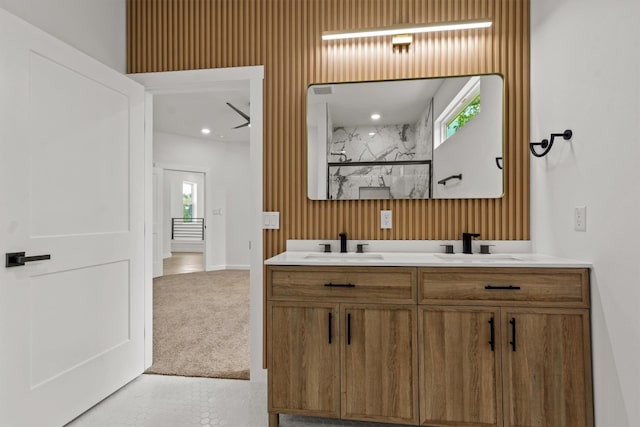 bathroom with vanity, a tile shower, and a wealth of natural light